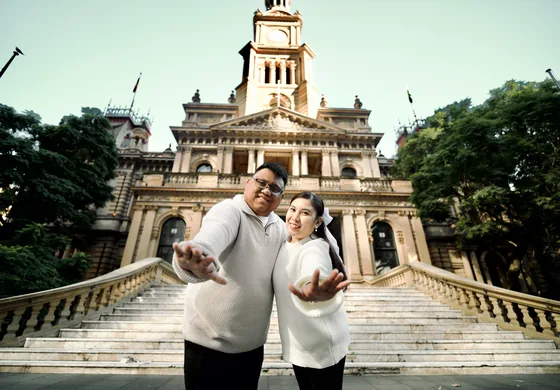 Reaching out from the steps of a grand sandstone civic building.