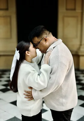 A close embrace, foreheads together, on a chequered marble floor.