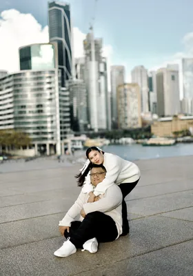 Laughing together with the Sydney city skyline behind them.