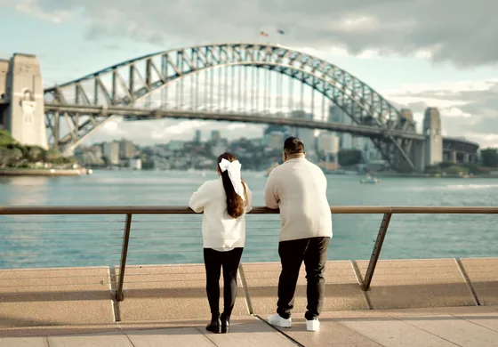 At the harbour railing, looking out towards the Sydney Harbour Bridge.