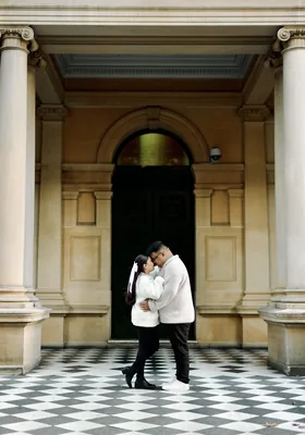Dancing on a chequered marble floor beneath a stone archway.